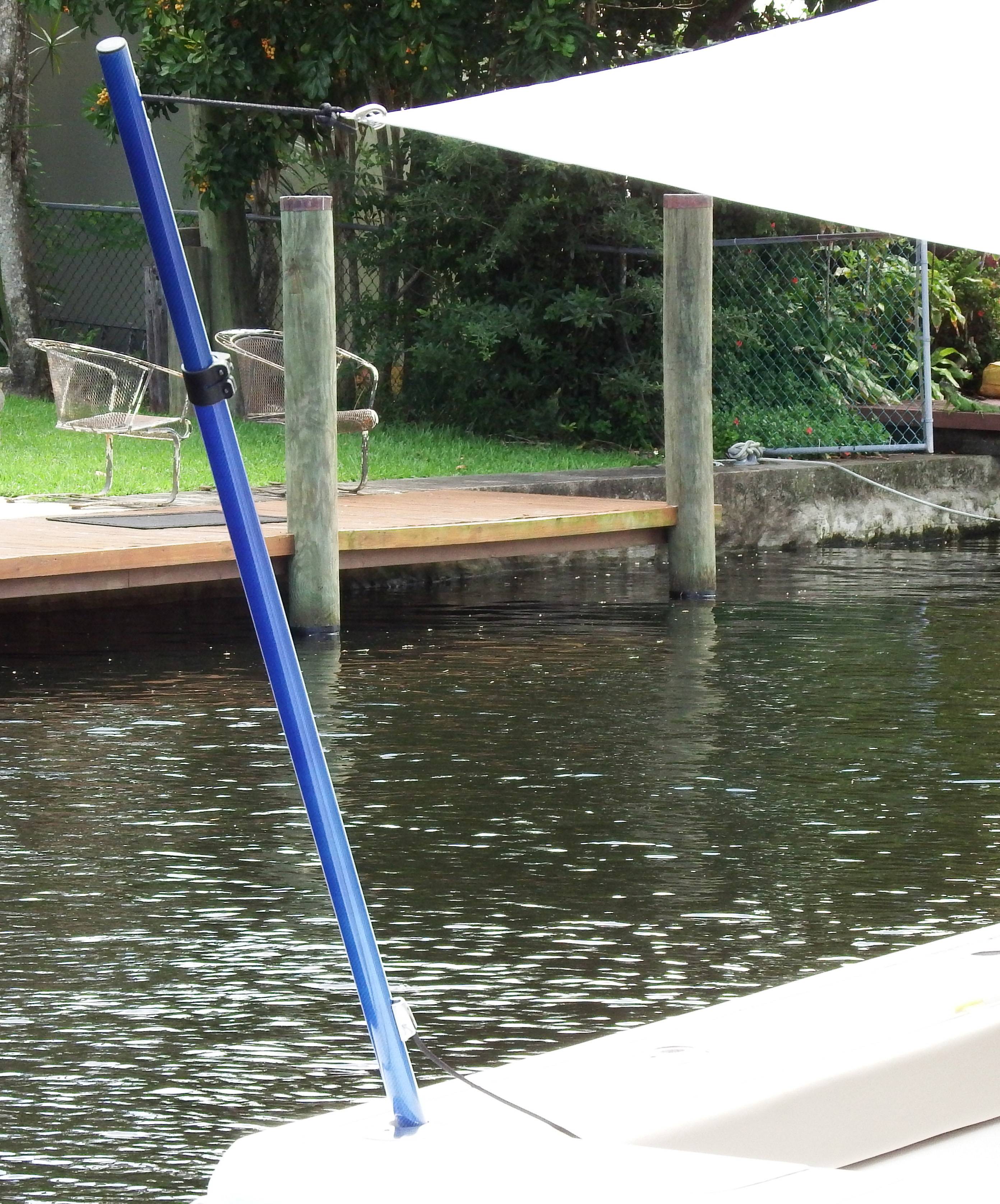 A close up image of a blue Carbiepole holding up a white boat shade.